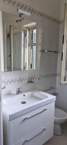 a bathroom with a sink and a mirror and a toilet at Giaro's Home in Pompei