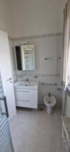 a white bathroom with a sink and a toilet at Giaro's Home in Pompei +3 photos