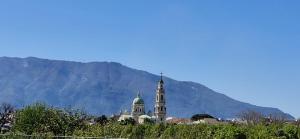 a building with a tower with a mountain in the background at Giaro's Home in Pompei