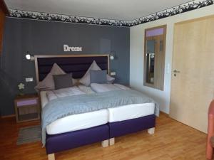 a bedroom with a large bed with a blue comforter at Haus Meeresblick in Heiligenhafen