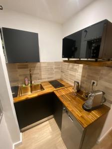 a small kitchen with a sink and a microwave at Appartement City Edge en centre-ville de Saint-Denis in Maison Henou +9 photos