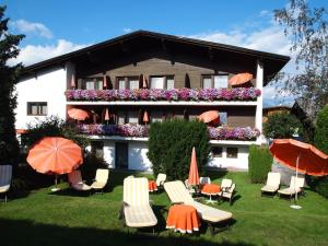 a hotel with chairs and umbrellas in the yard at Hotel Sonnhof in Innsbruck