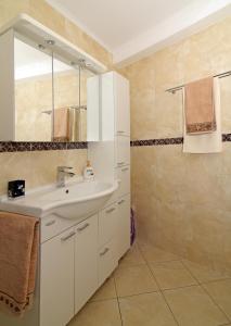 a bathroom with a sink and a mirror at Apartment River Rose in Mokošica