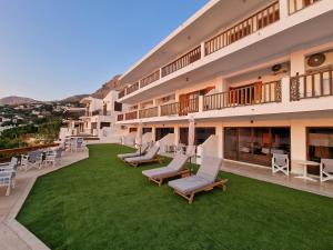 a hotel with chairs and tables and a lawn at Australia Apartments in Kalymnos