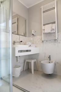 a white bathroom with a sink and a shower at Hotel Europeo in Sottomarina