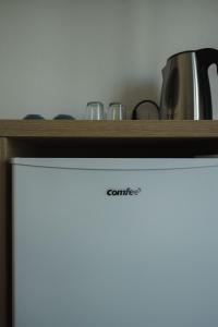 a white refrigerator with a shelf on top of it at Athena's & Kosta's Rooms Himara in Himare