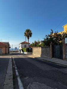 an empty street with a fence and palm trees at Casa del Corso in Parghelia