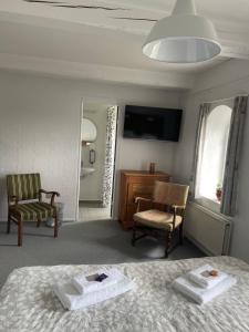 a bedroom with a bed and a chair and a tv at Bjerremark Hotel og Kursuscenter in Tønder