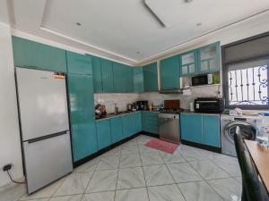 a kitchen with blue cabinets and a white refrigerator at Villa Aronora in Rabat