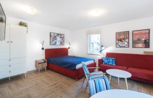 a bedroom with a bed and a couch and a table at Wojtek - domki letniskowe i pokoje, animacje, melex na plażę in Dziwnów