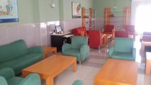 a waiting room with colorful chairs and tables at Hotel Alameda in Villaviciosa