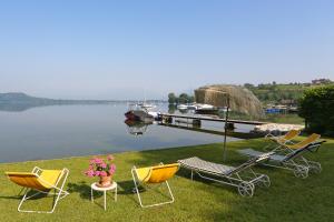 a group of chairs sitting on the grass near a dock at Il Giardino Sul Lago in Viverone +26 photos