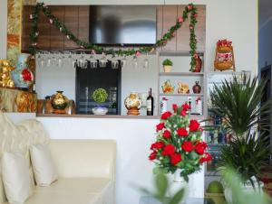a living room with a white couch and red flowers at Sea View Hotel Phan Thiet in Bình Sum