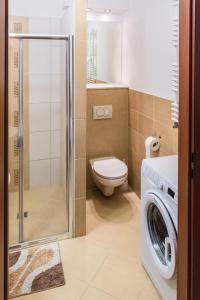 Un baño con inodoro y lavadora. en Apartament z ogródkiem w Parku Zdrojowym, en Świnoujście