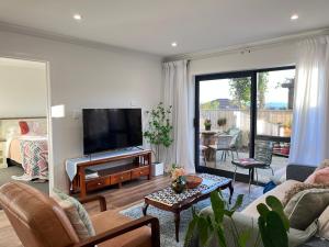 a living room with a flat screen tv and a couch at Brand New 2-Bedroom Retreat in Quiet Cul-de-Sac in Hamilton