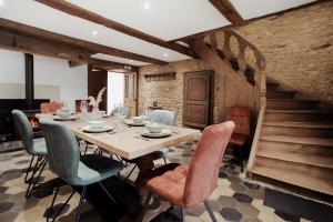 a dining room with a wooden table and chairs at Gîte Saint-Roch in Florenville