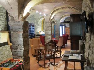 Mas Pineda في Oix: غرفة معيشة مع جدران حجرية ومدفأة