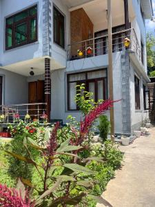 a house with flowers in front of it at Al Mubeen home stay in Nishāt