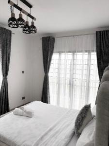 ein Schlafzimmer mit einem Bett und einem großen Fenster in der Unterkunft Sparkles B&Bs in Nairobi