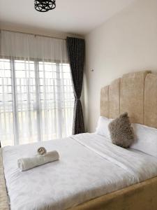 ein Schlafzimmer mit einem großen Bett mit einem großen Fenster in der Unterkunft Sparkles B&Bs in Nairobi