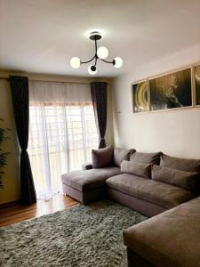 ein Wohnzimmer mit Couch und großem Fenster in der Unterkunft Sparkles B&Bs in Nairobi