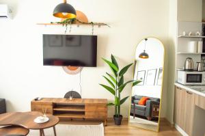 ein Wohnzimmer mit einem TV und einem Spiegel in der Unterkunft Luxe Suite MAI36 in Esenyurt