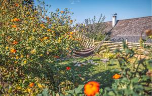 a garden with a hammock and orange flowers at Awesome Home In Stegersbach With Sauna in Stegersbach