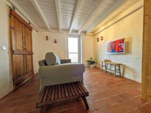 un salon avec une chaise et une table dans l'établissement Laranjeira 2 by AlmaAlgarvia, à Santa Bárbara de Nexe