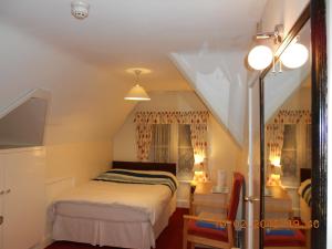 a small bedroom with a bed and a staircase at Acorn Lodge Guest House in Gosport