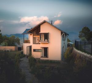 a small white house with a balcony and a fence at The Chitai Life in Almora +68 photos