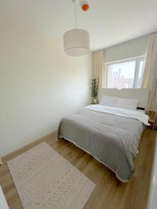 ein weißes Schlafzimmer mit einem Bett und einem Fenster in der Unterkunft Luxe Suite MAI36 in Esenyurt