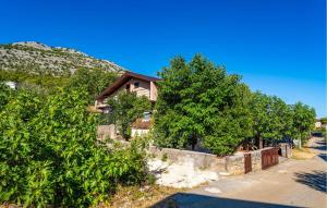 a house with a fence and trees next to a street at Beautiful Home In Starigrad - Paklenica With Wifi in Starigrad-Paklenica