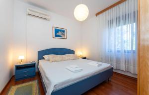 a bedroom with a blue bed and a window at Beautiful Home In Starigrad - Paklenica With Wifi in Starigrad-Paklenica