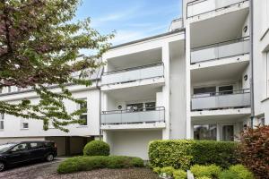 an apartment building with a car parked in the driveway at The Bright Urban Calm Basel St Louis in Saint-Louis