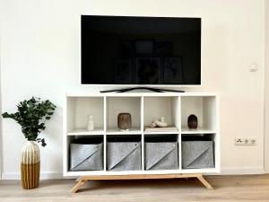 a white entertainment center with a tv on top at Apartment Alfred in Essen
