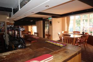 a bar in a restaurant with a table and chairs at The Sun Inn in Whitfield