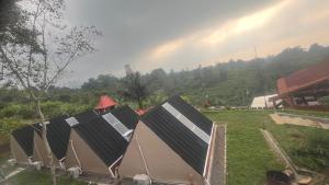 a row of tents in a field with a rainbow in the background at camping camp modern in Ciater