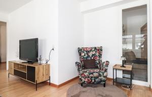a living room with a chair and a tv at Ferienwohnung In Bludenz in Bludenz