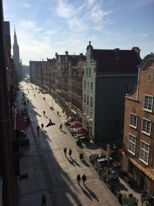 a group of people walking down a street with buildings at Liberum Residence Old Town in Gdańsk +52 photos