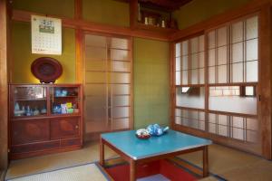 a room with a blue table and a cabinet at guesthouse Emi 笑み NIKKO in Nikko