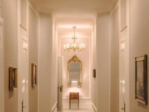 a hallway in a home with a chandelier at Fairmont Hotel Vier Jahreszeiten in Hamburg