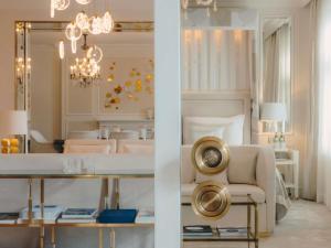 a living room with a large mirror and a dining room at Fairmont Hotel Vier Jahreszeiten in Hamburg