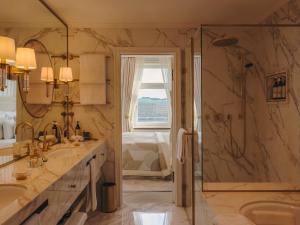a bathroom with a shower and two sinks and a shower at Fairmont Hotel Vier Jahreszeiten in Hamburg