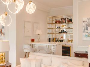 a living room with white chairs and a counter at Fairmont Hotel Vier Jahreszeiten in Hamburg