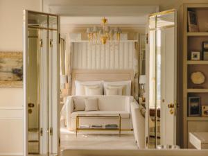 a bedroom with a white bed and a chandelier at Fairmont Hotel Vier Jahreszeiten in Hamburg