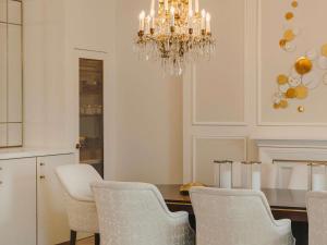 a dining room with a chandelier and a table and chairs at Fairmont Hotel Vier Jahreszeiten in Hamburg