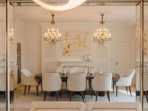 a dining room with a table and chairs and chandeliers at Fairmont Hotel Vier Jahreszeiten in Hamburg