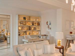 a white living room with a white couch and chairs at Fairmont Hotel Vier Jahreszeiten in Hamburg