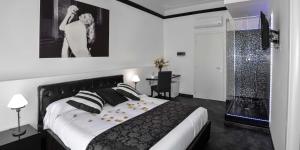 Schlafzimmer mit einem schwarzen und weißen Bett und einem Schreibtisch in der Unterkunft Good Life Via Veneto in Rom