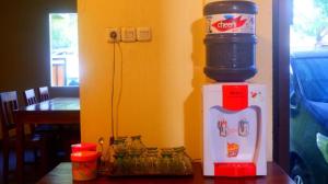 a drink dispenser sitting on top of a refrigerator at Hotel Manggala Syariah in Pacitan